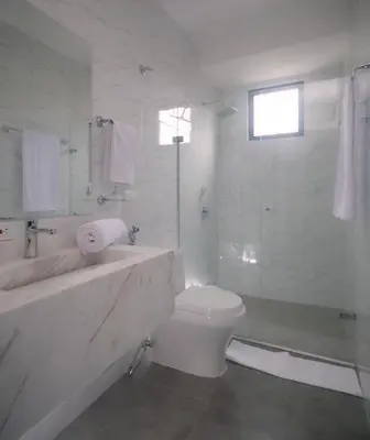 a white bathroom with a toilet and a shower at Edificio Casa Tabor in Barranquilla