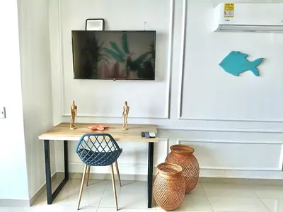 a table and a chair in a room with a tv at New Apartments with great Sunsets near historic center and beach in Cartagena de Indias