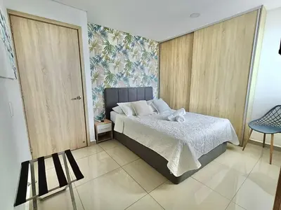 a bedroom with a bed and a chair in it at New Apartments with great Sunsets near historic center and beach in Cartagena de Indias