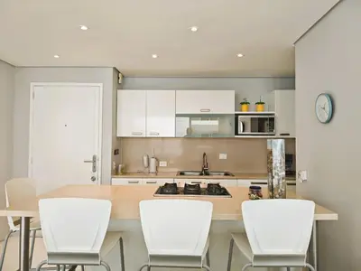 a kitchen with white cabinets and a table and chairs at Morros 3 Apartamentos de Lujo in Cartagena de Indias