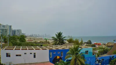 a building on the beach with the ocean in the background at Hotel La Yarolina SAS in Cartagena de Indias