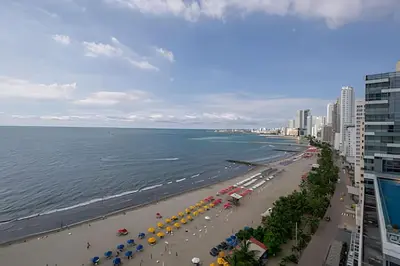 a view of a beach with umbrellas and the ocean at Laurdhomes Palmetto Beach Sea View, for working in Cartagena de Indias
