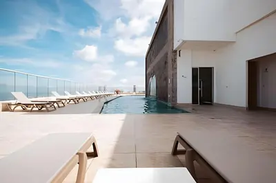 a balcony with tables and benches on a building at Laurdhomes Palmetto Beach Sea View, for working in Cartagena de Indias