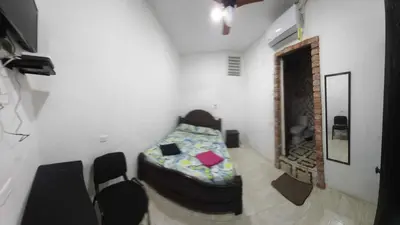 a bedroom with a bed and chairs in a room at HOSTAL EL BALCONCITO in Cartagena de Indias