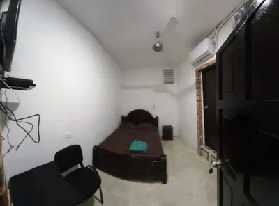 a room with a bed and a couch and a tv at HOSTAL EL BALCONCITO in Cartagena de Indias