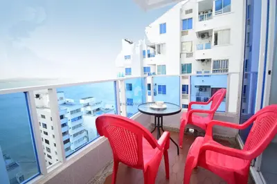a balcony with red chairs and a table and a building at apartamento con vista piso 20 in Cartagena de Indias