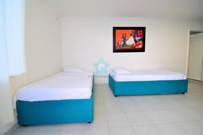 two beds in a room with a picture on the wall at apartamento con vista piso 20 in Cartagena de Indias