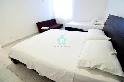 a hotel room with two beds and a chair at apartamento con vista piso 20 in Cartagena de Indias