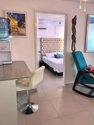 a room with a bedroom with a bed and a table and chairs at Hermoso apartamento con vista al mar in Cartagena de Indias