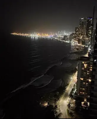 a view of the ocean at night with a city at apartamento en bocagrande in Cartagena de Indias