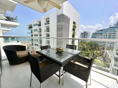 a table and chairs on a balcony with a view of the ocean at Hermoso apartamento familiar /acceso directo a la playa. Morros 3 in Cartagena de Indias
