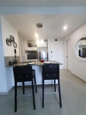 a kitchen with two chairs and a counter top at Espectacular apartamento Morros Epic Cartagena, Acceso directo a la playa in Cartagena de Indias
