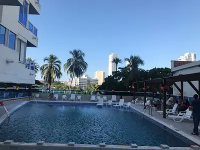 a large swimming pool with chairs and palm trees at CARTAGENA LA FANTASTICA in Cartagena de Indias
