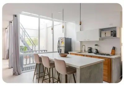 a kitchen with a table and chairs and a refrigerator at Casa Bacoba in Santa Marta