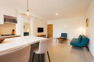 a kitchen and living room with a blue couch and chairs at Casa Bacoba in Santa Marta