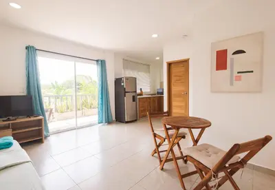 a living room with a table and chairs and a kitchen at Casa Bacoba in Santa Marta