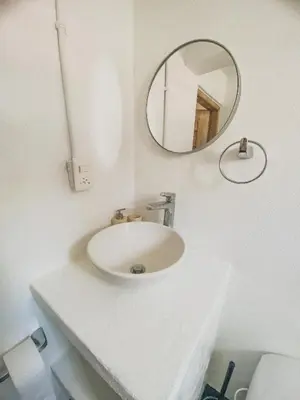 a white bathroom with a sink and a mirror at Mamallena Beachside Rincon del Mar in Rincón