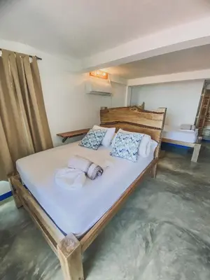 a bedroom with a large bed with towels on it at Mamallena Beachside Rincon del Mar in Rincón