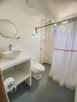 a bathroom with a sink and a toilet and a mirror at Mamallena Beachside Rincon del Mar in Rincón