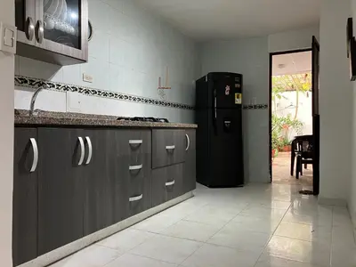 a kitchen with a black refrigerator and gray cabinets at Casa Encanto Cartagena Colombia in Cartagena de Indias