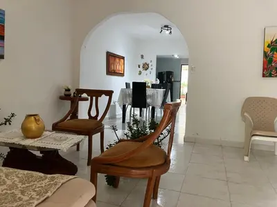 a living room with chairs and a dining room with a table at Casa Encanto Cartagena Colombia in Cartagena de Indias