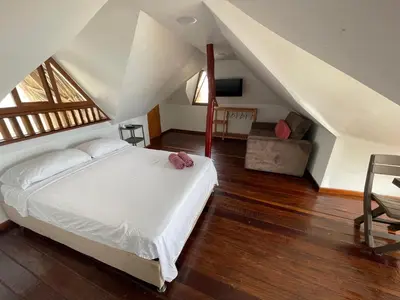 a bedroom with a white bed in a attic at Cabaña Yalis SAS in Cartagena de Indias