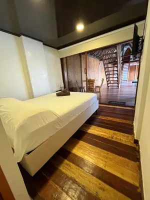 a bedroom with a large bed and a wooden floor at Cabaña Yalis SAS in Cartagena de Indias
