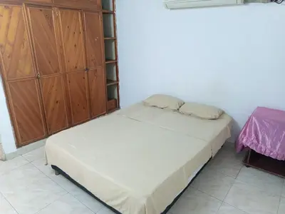 a small bedroom with a bed and a cabinet at Apartamento Excelente Ubicación Cartagena - Nuevo Bosque - Seguridad in Cartagena de Indias