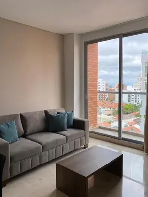 a living room with a couch and a large window at BUENAVISTA PLAZA APARTA HOTEL in Barranquilla