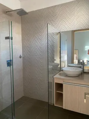 a bathroom with a sink and a glass shower at BUENAVISTA PLAZA APARTA HOTEL in Barranquilla