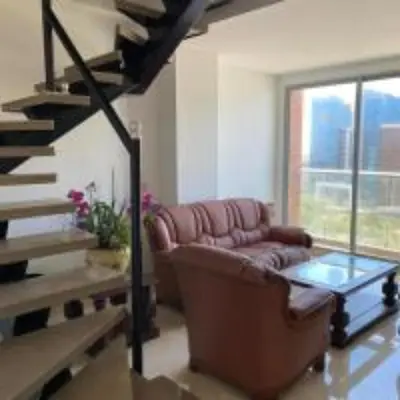 a living room with a couch and a glass table at BUENAVISTA PLAZA APARTA HOTEL in Barranquilla