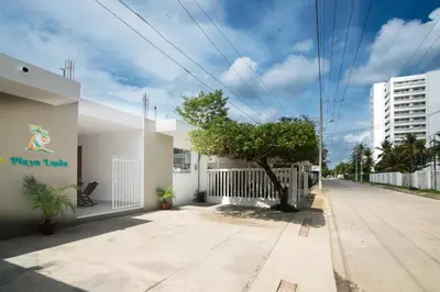 a building with a tree on the side of a street at Apartaestudio Playa Linda 101 in Coveñas