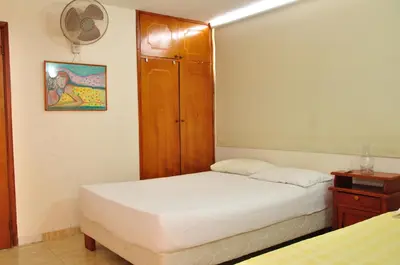a bedroom with two beds and a wooden cabinet at II-Nice and cozy 2 bedroom Apt BOCAGRANDE in Cartagena de Indias