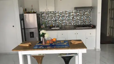 a kitchen with a table and a refrigerator at I-Nice 1 Bedroom Apt Laguito in Cartagena de Indias