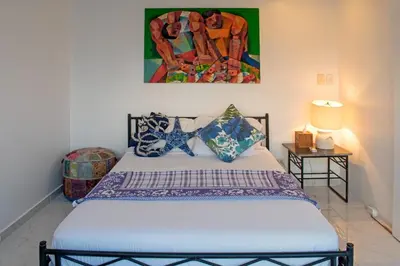 a bedroom with a bed with a painting on the wall at I-Nice 1 Bedroom Apt Laguito in Cartagena de Indias