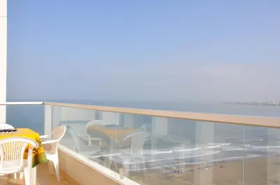 a balcony with a table and chairs and the ocean at I-Nice 1 Bedroom Apt Laguito in Cartagena de Indias