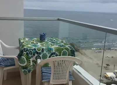 a table on a balcony with a view of the beach at I-Nice 1 Bedroom Apt Laguito in Cartagena de Indias
