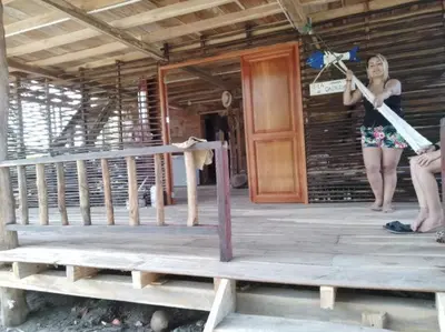 a woman standing on the porch of a house at LA GAITERA Cabaña in Moñitos