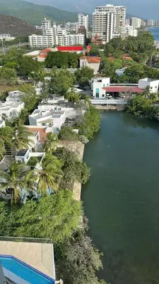 an aerial view of a river with buildings and trees at Edificio Sierra Beach Resort Pozos Colorados vista y salida al mar in Santa Marta