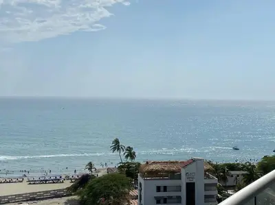 a view of a beach with people in the water at Edificio Sierra Beach Resort Pozos Colorados vista y salida al mar in Santa Marta
