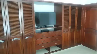 a entertainment center with a television and wooden cabinets at Apartamento en el Sector El Laguito in Cartagena de Indias