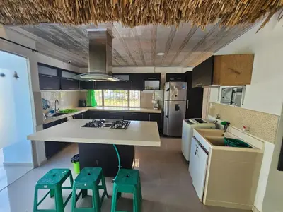 a kitchen with a counter and two stools in it at PLAYABRISAMAR in San Antero