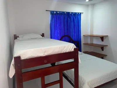 a bedroom with a bed and a blue curtain at Habitacion Playa Linda 102 in Coveñas