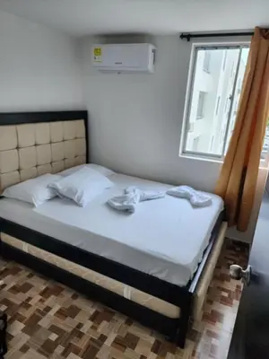 a bed in a room with two shoes on it at Lujoso apartamento amoblado en Coveñas cerca a la playa in Coveñas