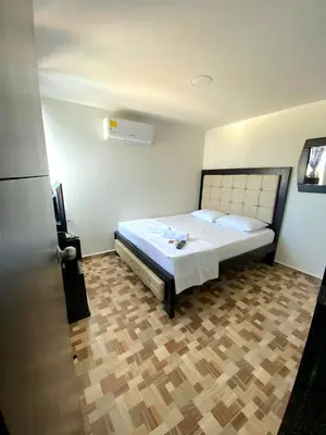 a bedroom with a bed and a wooden floor at Lujoso apartamento amoblado en Coveñas cerca a la playa in Coveñas