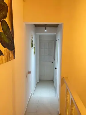 a hallway with a white door and yellow walls at Casa 39-33 in Cartagena de Indias