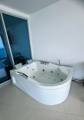 a white bath tub in a room with a window at Pent House 450 mts 360 front ocean view playa azul in Cartagena de Indias
