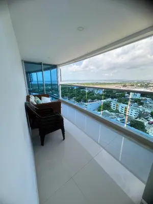 a room with a chair and a large window at Pent House 450 mts 360 front ocean view playa azul in Cartagena de Indias