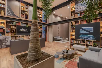 a library with a palm tree and a tv at Hotel Sites Barranquilla in Barranquilla