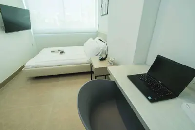 a room with a laptop on a desk with a couch at Suite de lujo Distrito 90 in Barranquilla